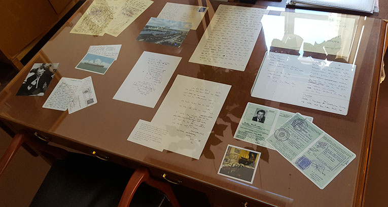 under en glasskiva på skrivbordet ligger foton och dokument med anknytning till Harry Martinson