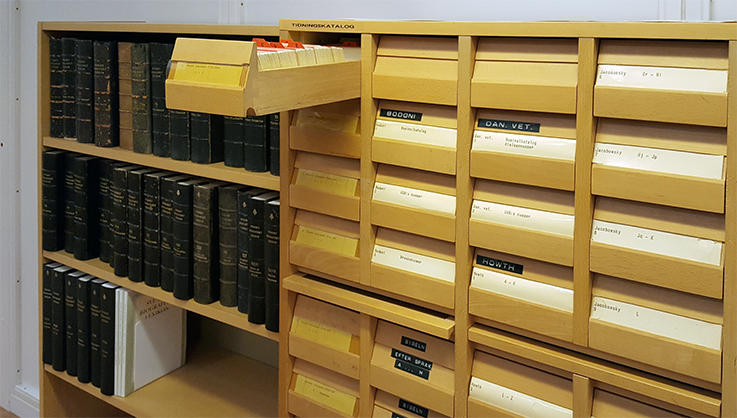 ett katalogskåp av trä med en låda utdragen