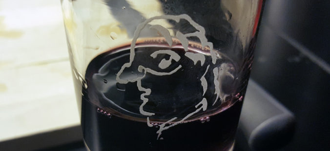 ett ingraverat ansikte i profil på ett glas