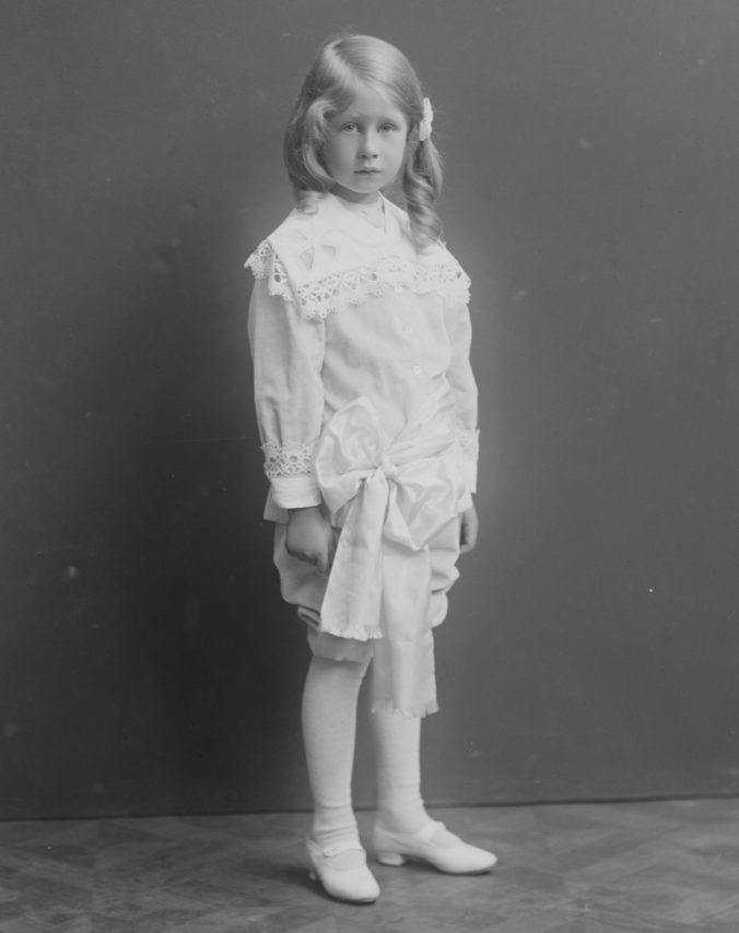beskuren svartvit bild på pojke i vita kläder
