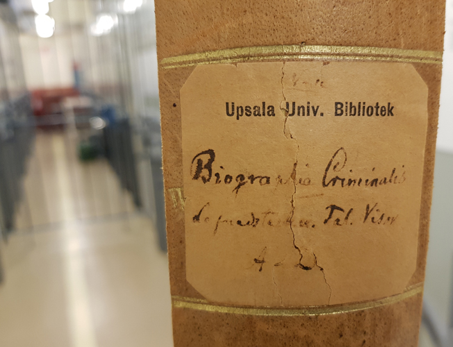i ett magasin med en gallergrind i bakgrunden syns en kapsel med den handskrivna titeln Biographia criminalis